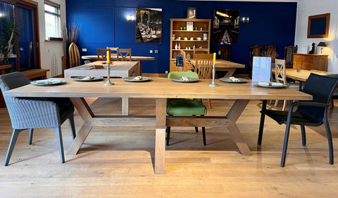 Angled Oak Dining room table and chairs against a blue wall.