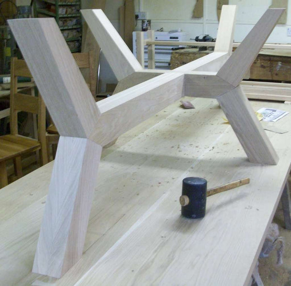 Contemporary angled oak dining table base in workshop