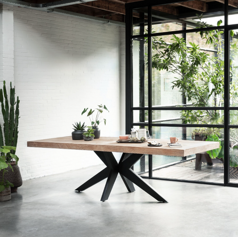 Teak dining table on a black powder coated metal base