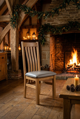 Oak dining chair with leather seat pad beside an open fire at Christmas time