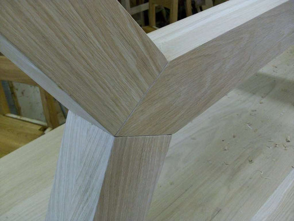 Contemporary angled oak dining table leg close up