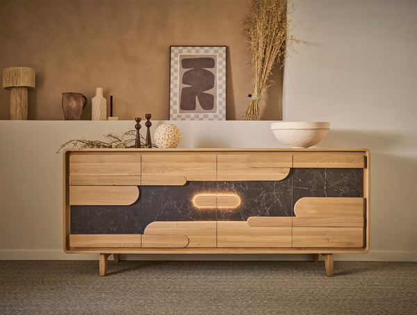 A mid-century modern wooden sideboard with a black ceramic inlay and integrated LED lighting, styled in a warm, minimalist room setting.