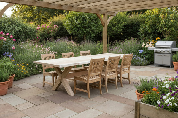 Handmade cross leg oak garden table with waney live edge top on patio with garden