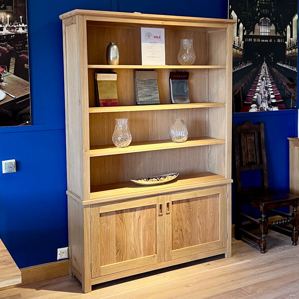 Handmade oak bookcase with double cupboard below in a showrtoom setting