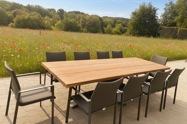 Outside Dining Furniture - Tenterden Oak Table on patio with chairs in wild flower meadow