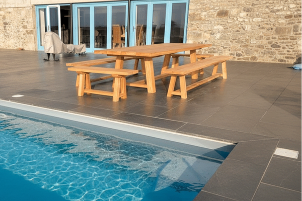 Garden table and benches on patio with pool