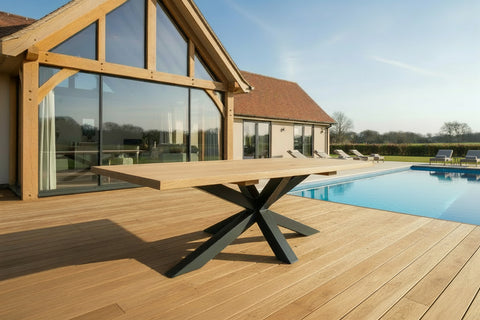 Handmade oak and steel Garden Table on decking in front of oak framed house and swimming pool