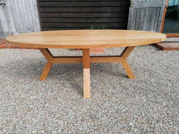 Solid oak oval top dining table on an angled base