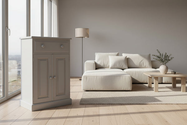 A light grey drinks cabinet with a single drawer and two doors, set on a wooden deck with a grassy background.
