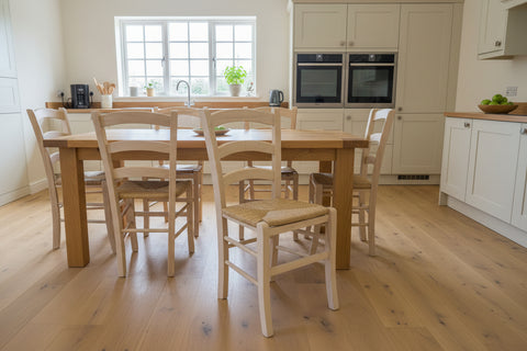 Wooden chair with a woven seat on a wooden floor in a room with furniture.