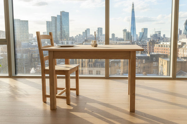 Small handmade oak table side view in London apartment with views over the city