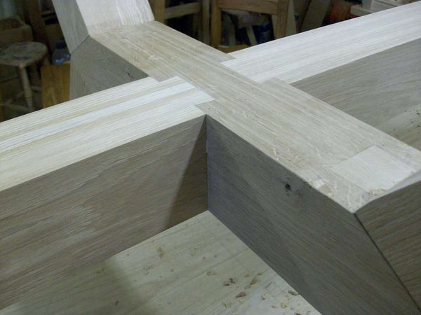 Contemporary angled oak dining table base close up of joints