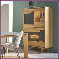 A tall wooden cabinet with glass doors and a built-in shelf, shown in a dining room setting next to a table and chair.