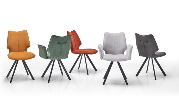 Five modern dining chairs with sculptural wingback backs and black metal tripod legs, shown in orange, sage green, rust red, light gray, and charcoal gray upholstery on a white studio background.