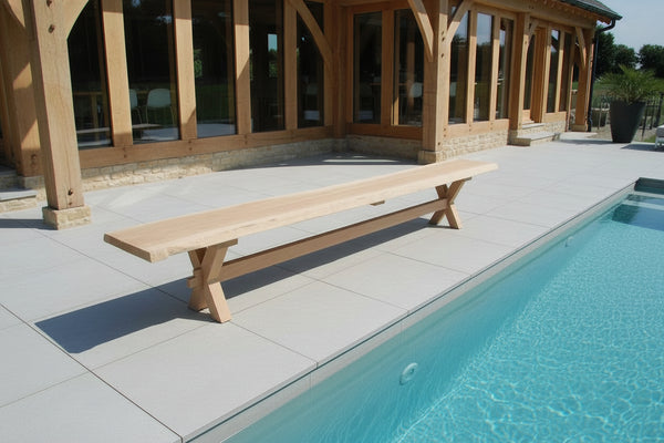 Outdoor Dining Furniture - Cross Leg Bench on patio of oak framed house by pool