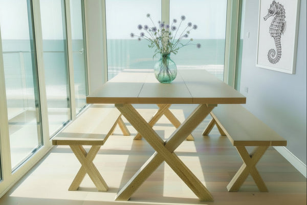 End view of handmade oak petit cross leg table in a modern house with views of the sea