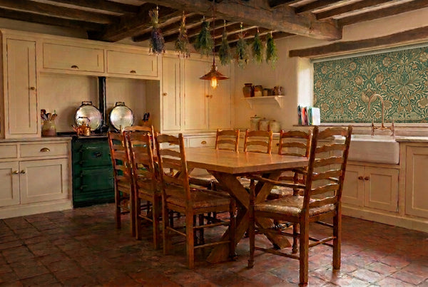 Handmade oak cross leg dining table with handmade traditional ladderback chairs in an English kitchen