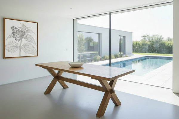 Handmade Sussex Oak dining table in a contemporary room with with view of pool and garden