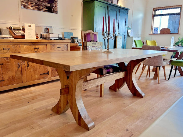 Handmade oak Moselle dining table by Country Ways Oak Furniture Makers in the showroom with other examples of handmade furniture at Little Swailes Green Farm