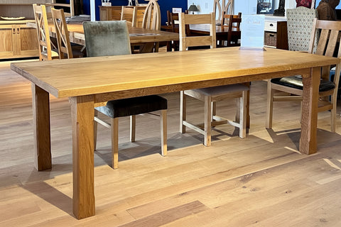 Handmade oak boarded refectory dining table with square stop-chamfered legs in Country Ways Oak Furniture Makers showroom