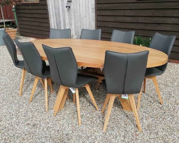 Sussex - Contemporary Angled Dining Table Oval Top outside of Country Ways showroom with set of leather upholstered Quad-Pod dining chairs