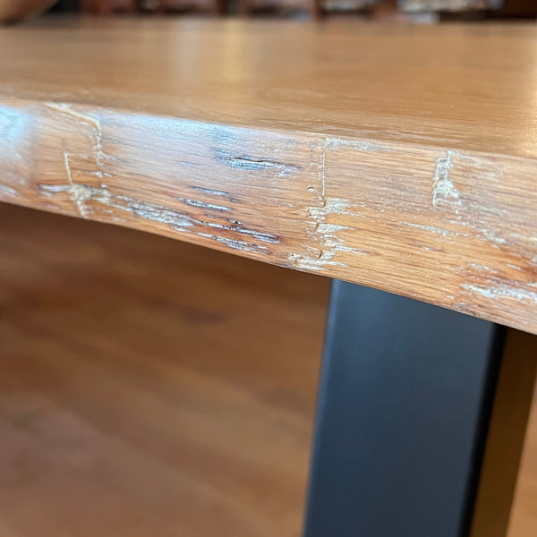 Close-up of handmade waney live edge oak table top and steel base