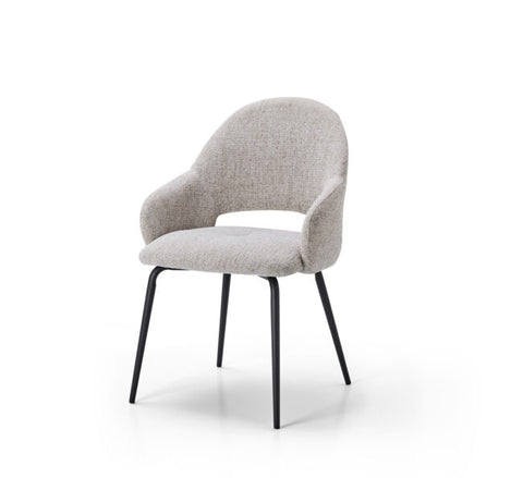 A modern upholstered dining chair with a curved back, integrated armrests, and a light beige textured fabric, supported by slim black metal legs, shown on a white background.