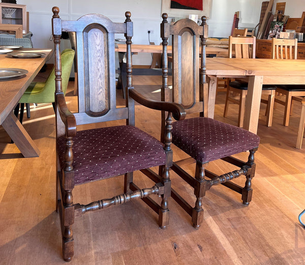 Oak panel back carver and side chair with upholstered seats a room with tables and chairs.