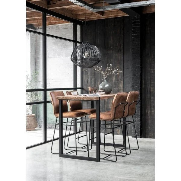 Reclaimed teak bar height table in a dining area brown leather chairs in a modern interior setting.