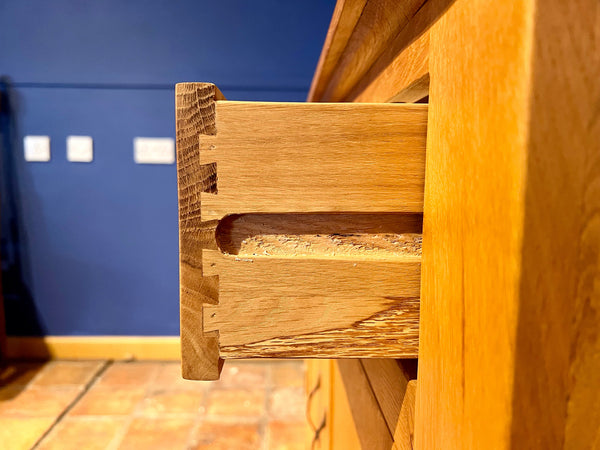 Close-up of Staplecross sideboard dovetail drawer detail with a blurred blue wall in the background