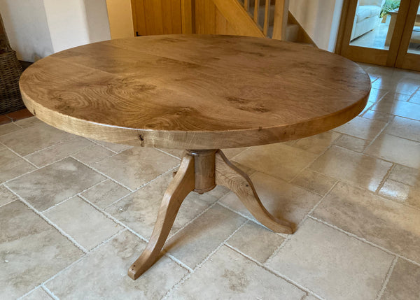 120 cm round oak pedestal table with a 45mm thick oak top in a home dining room setting