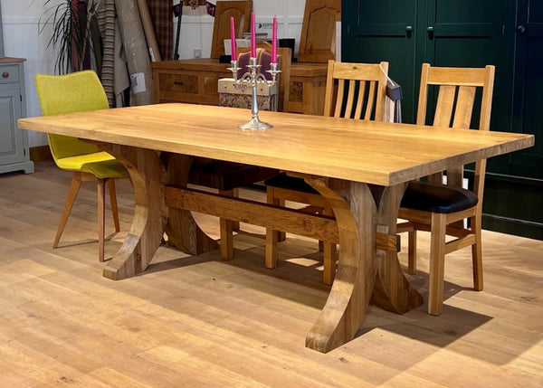 Handmade Moselle oak dining table with chairs in a  showroom setting