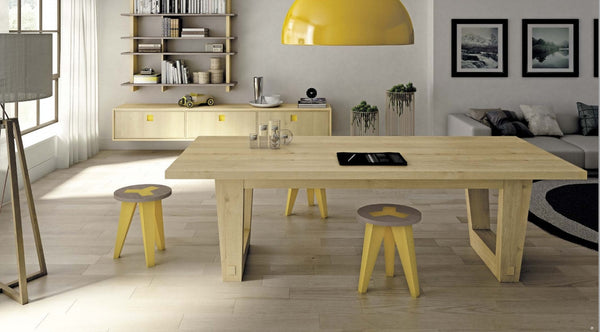 A contemporary style extending dining table made of oak wood, with a rectangular tabletop and four matching stools. The table has a natural wood finish and is set in a modern kitchen environment.