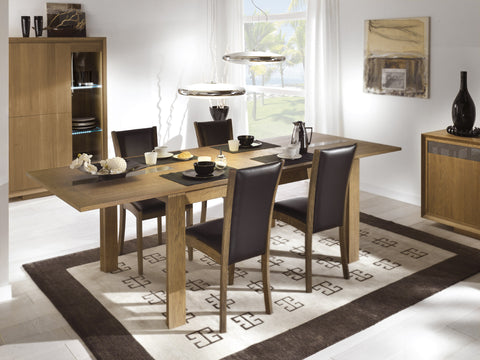 A Tuscany Contemporary Sienna Centrally Extending Dining Table with butterfly leaves, glass inserts, and a wood finish, set in a room with various dining room furniture.