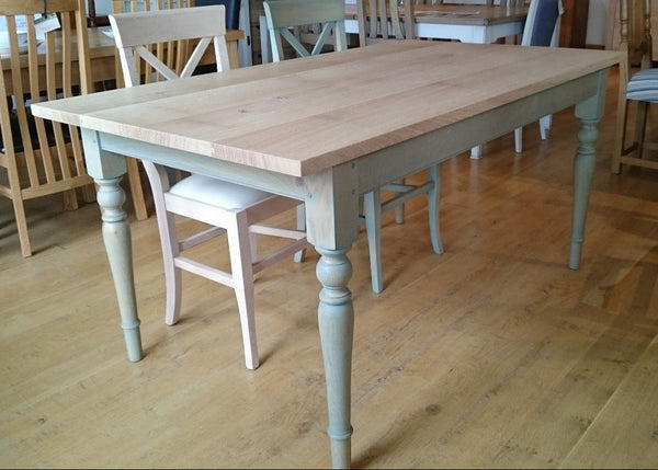 Georgian Windsor oak table close up with two wooden chairs in oak furniture showroom