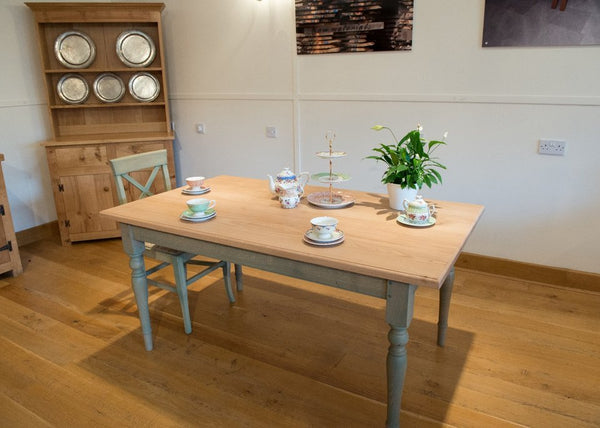 Georgian Windsor oak table with a dresser in a furniture showroom with light walls and an oak floor