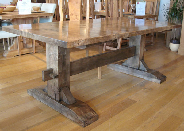Handmade trestle pillar oak dining table in Burr English oak in our Sussex showroom