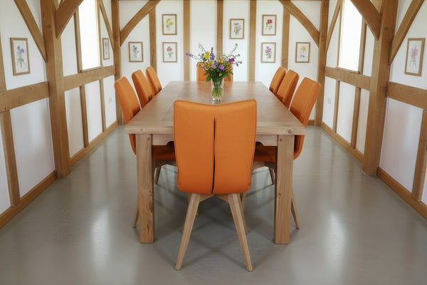 Orange Quadpod chairs with handmade Sussex farmhouse table in an oak framed dining room