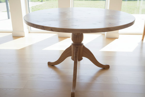 Oak circular Pedestal dining table in sunny room