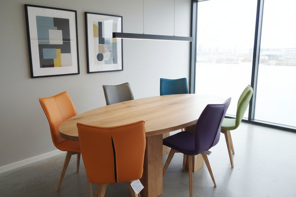 Leather Quadpod dining chairs in various colours around a handmade oval oak dining table