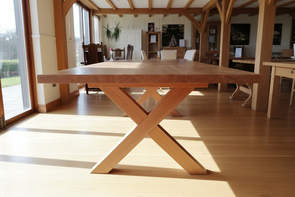 Modern version of a handmade sussex oak cross leg dining table with flush top, without stretcher connecting cross leg base.
