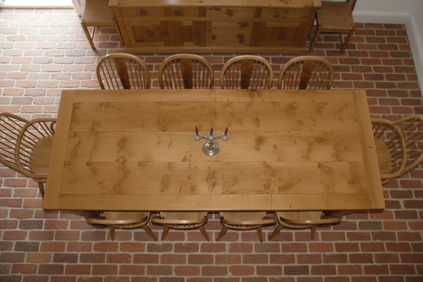 Pippy English oak framed refectory table top view in a room with a brick floor and oak sideboard