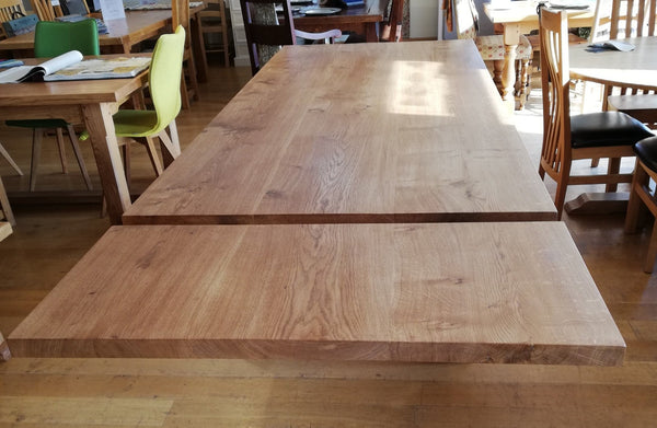 View of top and leaf of Sussex handmade extending oak table in a showroom setting