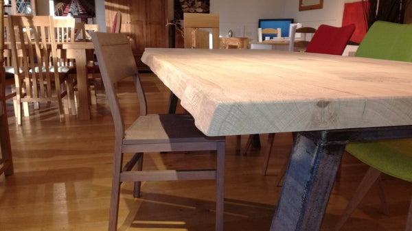 Live edge oak table on a steel base close up in our showroom